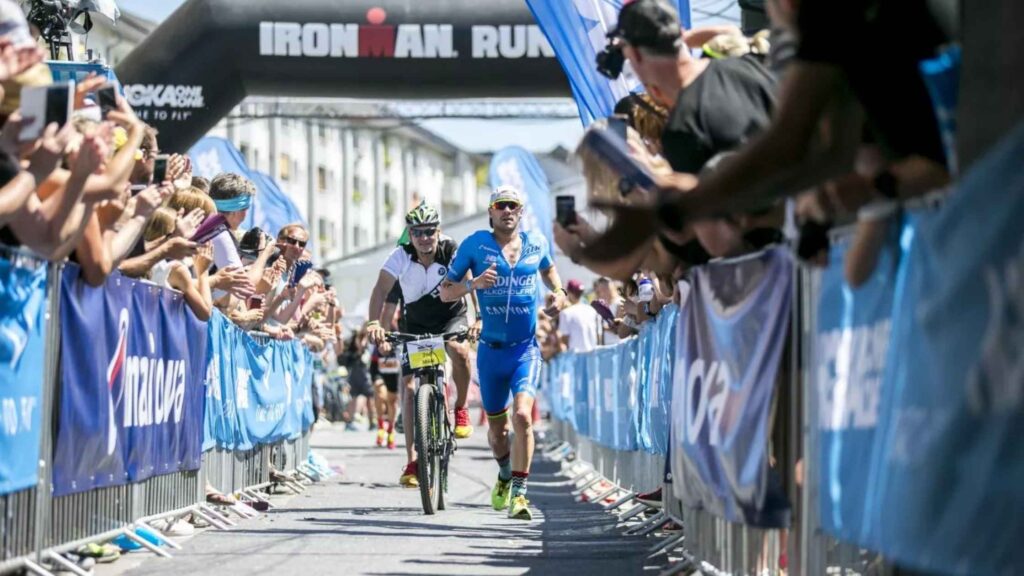 Triatleta corriendo en el tramo final del IRONMAN Frankfurt entre el público