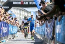 Triatleta corriendo en el tramo final del IRONMAN Frankfurt entre el público