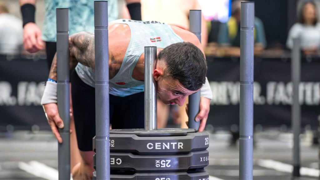 Deportista empujando un trineo de entrenamiento funcional en una prueba de Hyatlón
