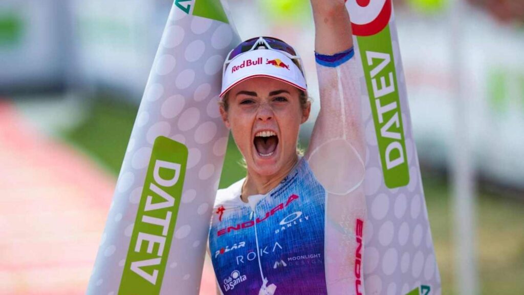 Lucy Charles-Barclay celebra su victoria con la cinta de meta de DATEV Challenge Roth