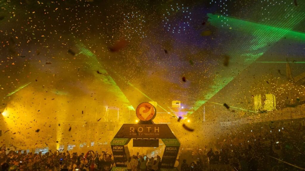 : Celebración en la meta del DATEV Challenge Roth con confeti, luces y público
