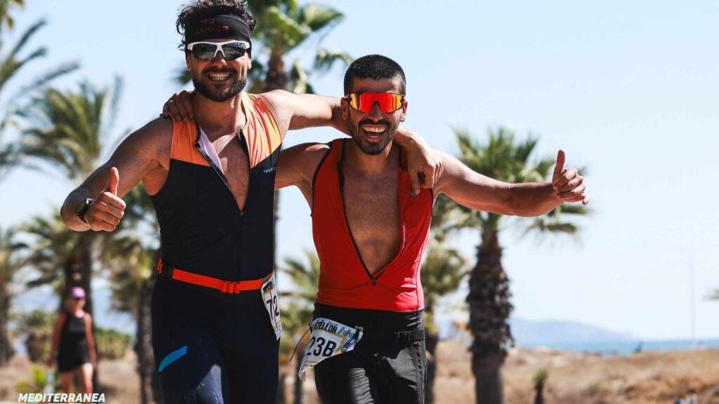 Dos triatletas celebran su participación en MTRI Castellón junto a la Playa del Pinar
