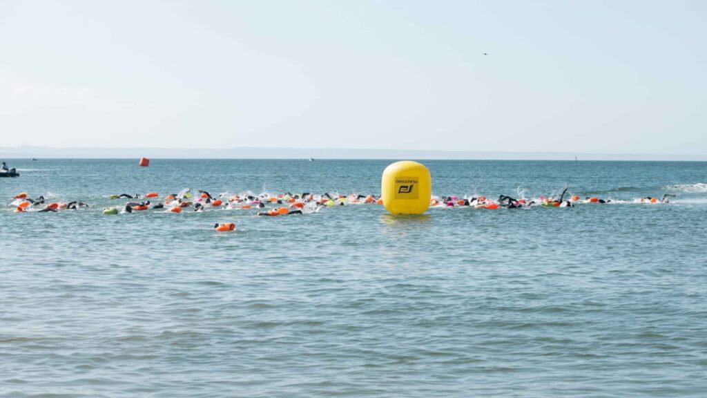 Schwimmer des Swim Grand Prix, die im offenen Wasser neben einer Markierungsboje antreten