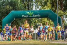 Salida de corredores en el Triatlón de Almazán bajo el arco de Caja Rural de Soria