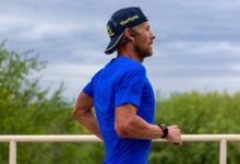 Sanders corriendo con camiseta azul durante una sesión de entrenamiento