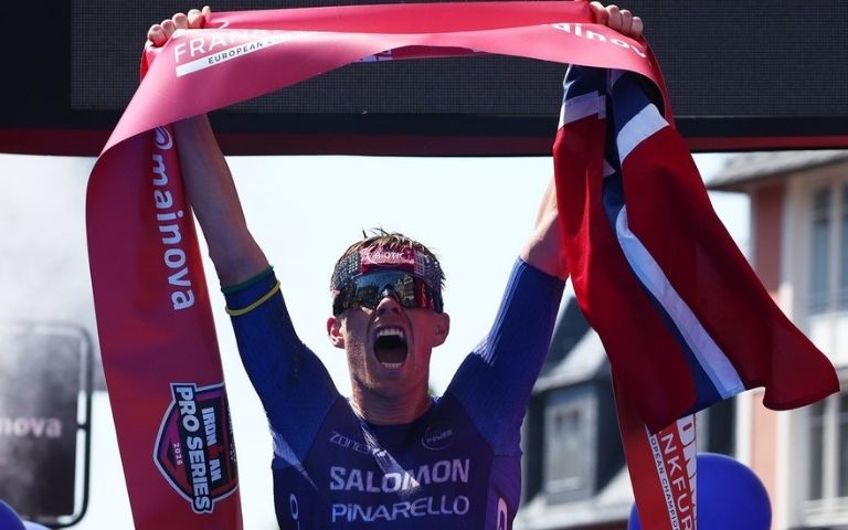 Casper Stornes celebra su victoria en el IRONMAN European Championship Frankfurt 2026 levantando la cinta de meta.