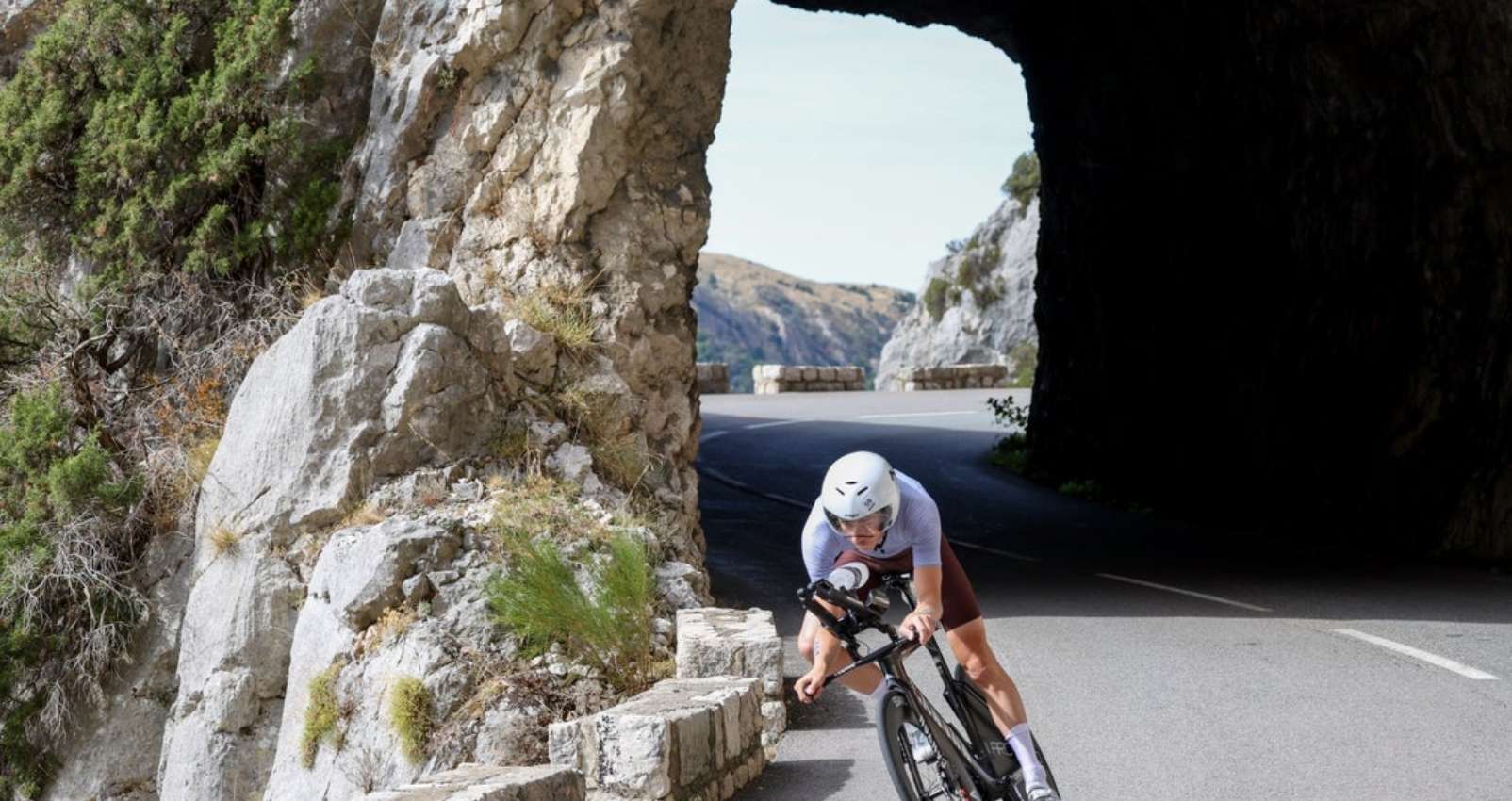 Triatleta en bicicleta por una carretera de montaña en Niza