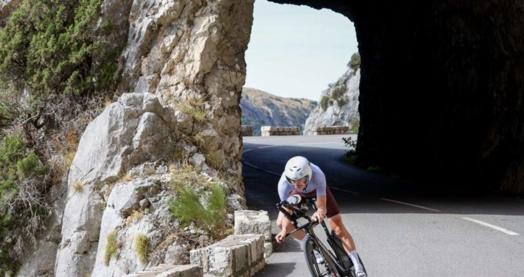 Triatleta en bicicleta por una carretera de montaña en Niza