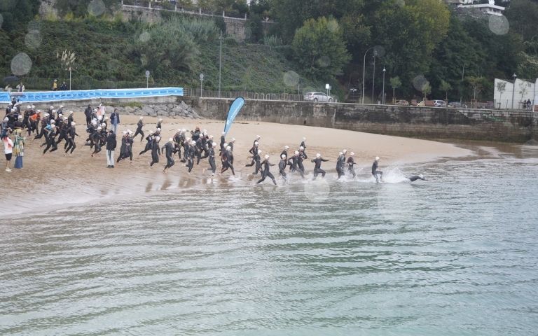 Triatletas entrando al agua en la salida de natación del Triatlón Ciudad de Santander