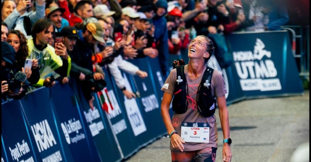 Courtney Dauwalter sonríe al llegar a meta en la UTMB, entre los aplausos del público