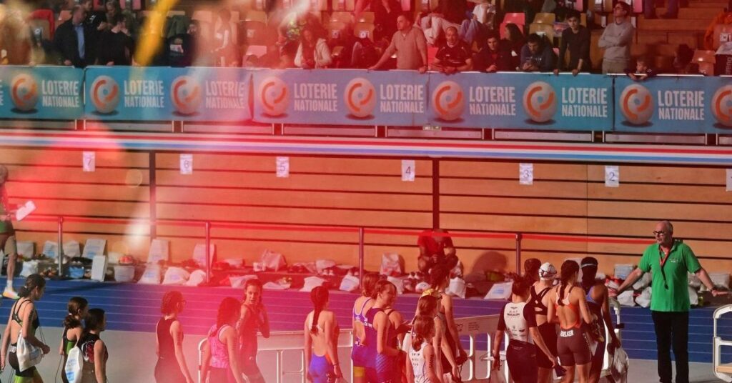 Deportistas junto a la piscina y la pista cubierta durante una competición de acuatlón indoor