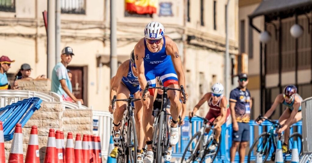 Varias triatletas compiten en bicicleta por un circuito urbano de Melilla, con el dorsal 30 en primer plano