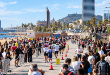 Triatletas corriendo por el paseo marítimo de Barcelona, con espectadores a ambos lados del recorrido