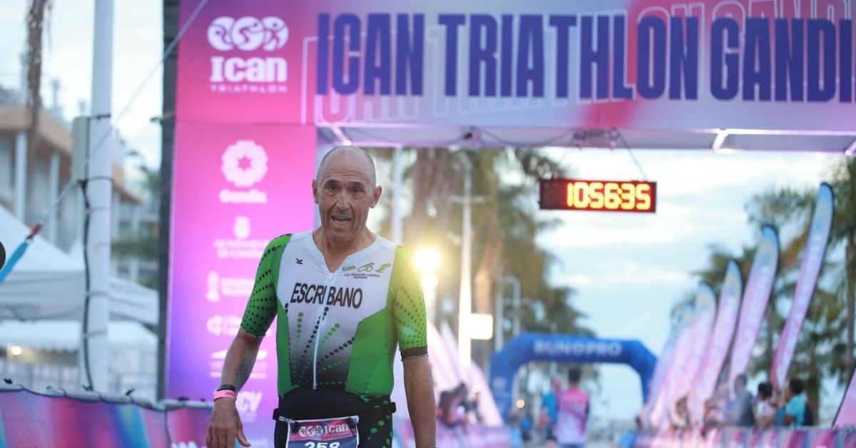 Triatleta con el apellido Escribano bajo el arco de meta del ICAN Triathlon Gandia