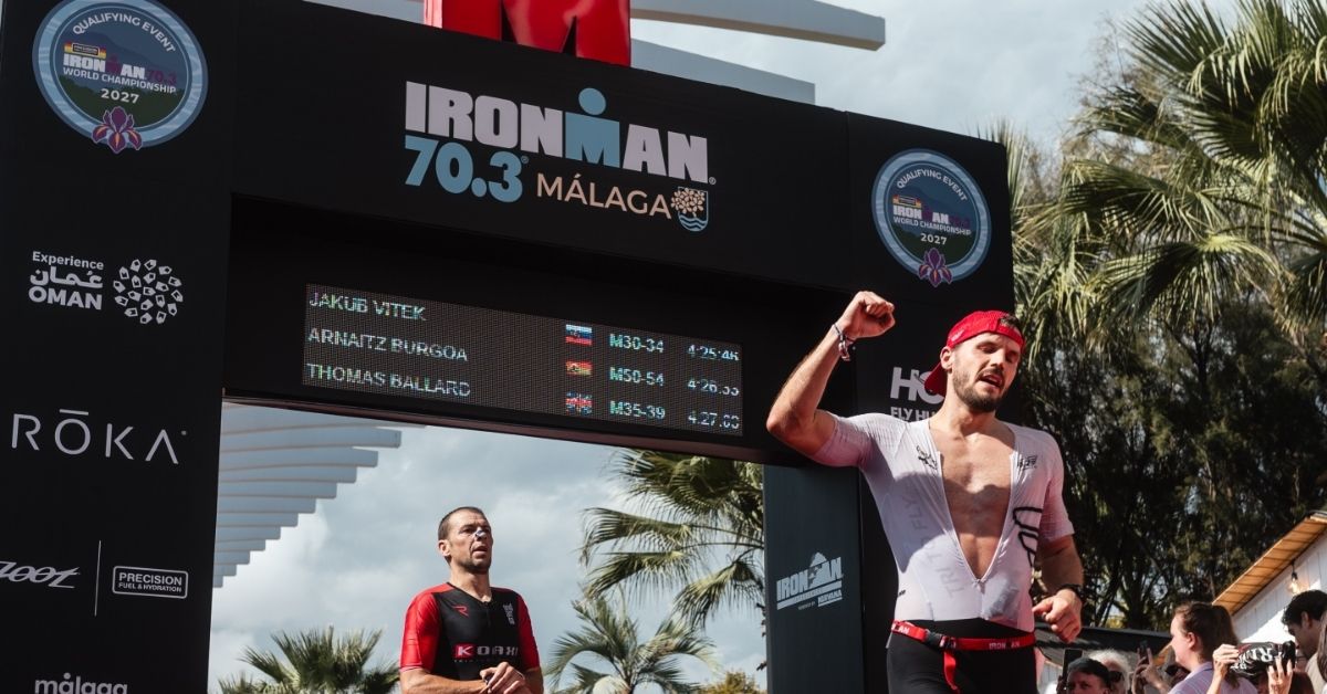 Triatletas cruzan la meta del IRONMAN 70.3 Málaga bajo el arco de llegada
