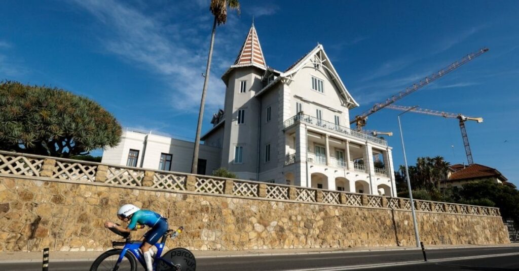Triatleta en bicicleta de contrarreloj junto al paseo marítimo de Cascais