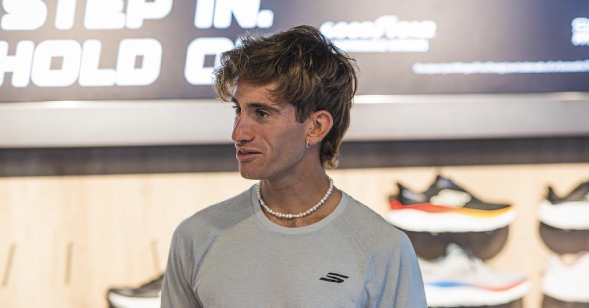 Javier Martín con camiseta de Skechers ante una exposición de zapatillas de running