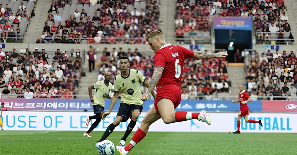 John Arne Riise golpea el balón durante un partido de fútbol con la camiseta roja y el dorsal 6