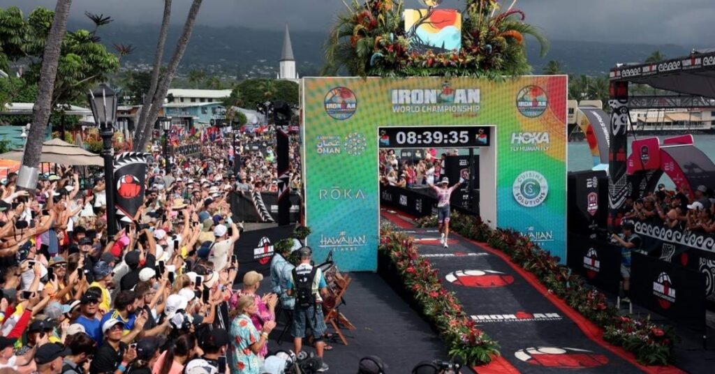 Zona de meta del Campeonato del Mundo IRONMAN Kona, en Hawái, con un triatleta llegando entre el público
