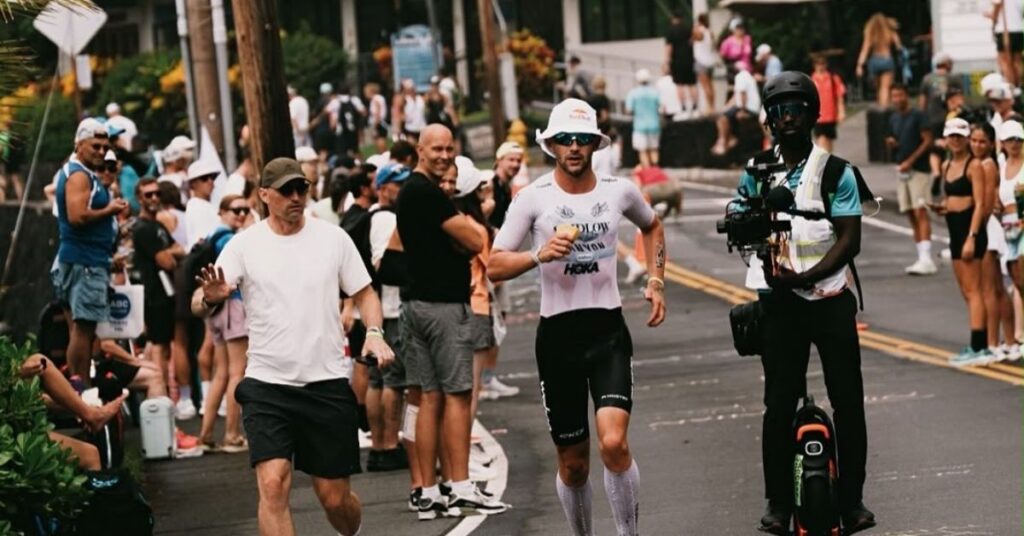 Triatleta corriendo en Kona acompañado por un cámara durante el Campeonato del Mundo IRONMAN 2026